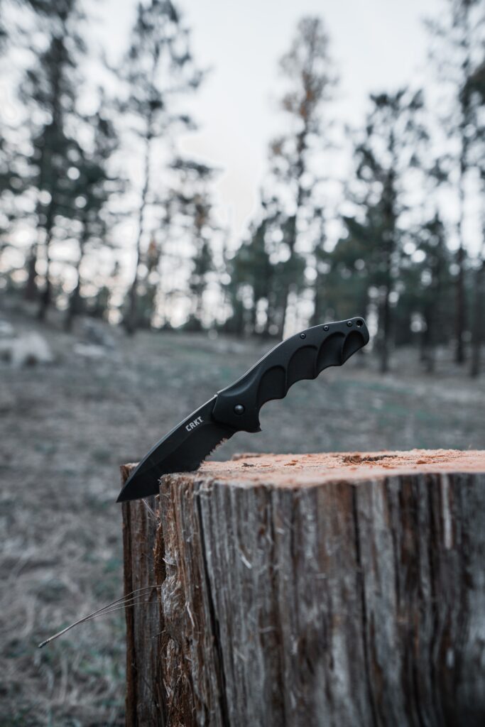 image of survival knife stuck in a stump.